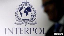 FILE PHOTO: A man passes an Interpol logo during the handing over ceremony of the new premises for Interpol's Global Complex for Innovation in Singapore