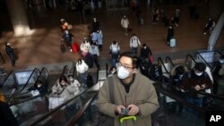 Viajeros en escaleras mecánicas en la Estación de Ferrocarril del Oeste de Beijing, el miércoles 18 de enero de 2023.