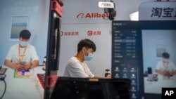 FILE - A staff member demonstrates live streaming at a booth from Chinese technology firm Alibaba at the China International Fair for Trade in Services in Beijing Sept. 2, 2022. The U.S. expanded export controls on advanced chips, including those used for artificial intelligence.