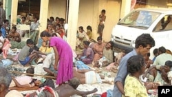 Sri Lankan ethnic Tamil victims of a shell attack wait outside a makeshift hospital in Tiger controlled No Fire Zone in Mullivaaykaal, May 10, 2009
