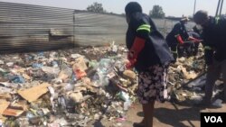 Bulawayo Metropolitan Minister and other people cleaning streets on Monday. 