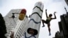 A runner is dressed in a costume depicting the Rio 2016 Olympic torch, decorated with a figure of Jamaica's Usain Bolt and a pill, before the annual "Sao Silvestre Run" (Saint Silvester Road Race), an international race through the streets of Sao Paulo, B