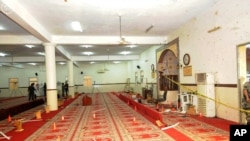 In this photo released by the Saudi Press Agency SPA, Saudi officials and investigators, background, check a mosque inside a police compound after a suicide bombing attack, in the city of Abha, the provincial capital of Asir, Aug. 6, 2015.