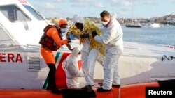 Một di dân sống sót sau một vụ đắm tàu được đưa lên cảng Lampedusa, ngày 11/2/2015.