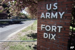 FILE - A truck drives through a gate at Fort Dix near Wrightstown, N.J., May 8, 2007.