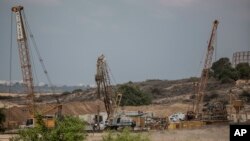 FILE - Heavy machinery works on a massive underground barrier on the Israeli side of the border with Gaza, Sept. 8, 2016.