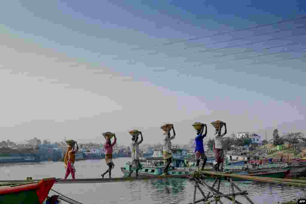 방글라데시 다카 외곽 갭톨리에서 인부들이 배에 실려있던 건축자재들을 옮기고 있다.