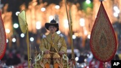 Thailand's King Maha Vajiralongkorn is transported on the royal palanquin by royal bearers during the Royal Procession outside the Grand Palace in Bangkok, Thailand, Thursday, Dec. 12, 2019. (AP Photo/Suganya Samnangjam)