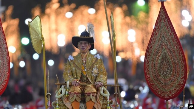 Thailand's King Maha Vajiralongkorn is transported on the royal palanquin by royal bearers during the Royal Procession outside the Grand Palace in Bangkok, Thailand, Thursday, Dec. 12, 2019. (AP Photo/Suganya Samnangjam)