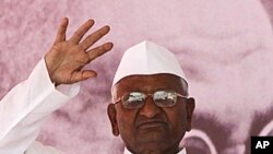 Indian anti-corruption activist Anna Hazare waves to supporters next to a portrait of Mahatma Gandhi on the first day of his hunger strike in Mumbai, India, December 27, 2011.