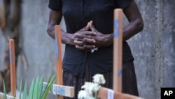 FILE - A relative of a victim of the Easter Sunday bomb blasts in Sri Lanka pays tribute at the burial site after a televised Sunday Mass by Sri Lankan Archbishop Cardinal Malcolm Ranjith, in Negombo, north of Colombo, Sri Lanka, April 28, 2019.