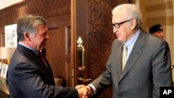 In this photo released by the Jordanian Royal Palace, Jordan's King Abdullah II, left, shakes hands with U.N. envoy on Syria, Lakhdar Brahimi, at the Royal Palace in Amman, Jordan, Oct. 23, 2013.