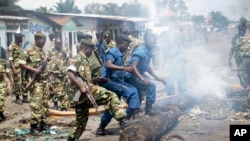 Policiers et soldats dégagent la rue barrée par des barricades, Bujumbura, 25 mai 2015.