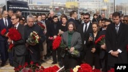 US Ambassador to Russia, Lynne Tracy (C) stands at attention during a flower laying ceremony along with ambassadors of foreign diplomatic missions at the memorial in memory of the victims of the terrorist attack at the Crocus City Hall concert venue a wee