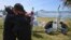 Relatives and friends of Alejandro Tagliaprieta, a crew member on the missing ARA San Juan submarine, embrace at the naval base where people hang flags and messages on the fence in Mar de Plata, Argentina, Nov. 24, 2017.