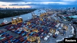 FILE - Containers await transport at a port along Chao Phraya River in Bangkok, Thailand, July 19, 2022. 