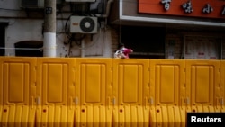 上海封城，两个孩子在围栏上向外张望。（2022年3月26日）