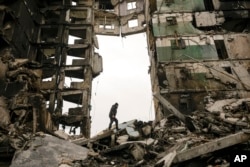 A resident looks for belongings in an apartment building destroyed during fighting between Ukrainian and Russian forces in Borodyanka, Ukraine, April 5, 2022.
