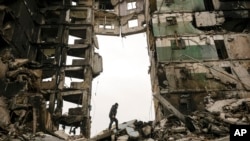 FILE: A resident looks for belongings in an apartment building destroyed during fighting between Ukrainian and Russian forces in Borodyanka, Ukraine, April 5, 2022.