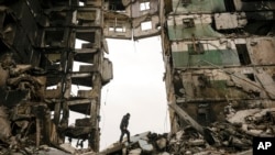 FILE - A resident looks for belongings in an apartment building destroyed during fighting between Ukrainian and Russian forces in Borodyanka, Ukraine, April 5, 2022.