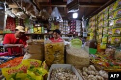 Para pedagang menunggu pelanggan di pasar tradisional di Tangerang, pada 3 April 2022. (Foto: AFP/Adek Berry)