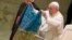 Pope Francis shows a flag that was brought to him from Bucha, Ukraine, during his weekly general audience in the Paul VI Hall, at the Vatican, Apr. 6, 2022. 