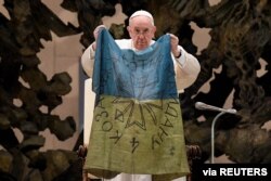 El Papa Francisco sostiene la bandera ucraniana que le fue enviada desde Bucha, un sitio devastado durante la invasión de Rusia, cerca de Kiev. En el Vaticano, el 6 de abril de 2022.