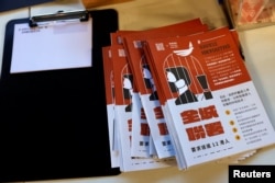 FILE - Leaflets and postcards are seen at a booth to encourage people to send postcards to twelve Hong Kong residents being held in the Chinese mainland after attempting to flee to Taiwan, in Hong Kong, China, Sept. 18, 2020.