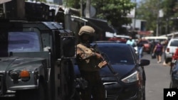 Soldados vigilan un puesto de control a la entrada de la comunidad de Las Palmas, un barrio que se supone está bajo el control de la pandilla Barrio 18 en San Salvador, El Salvador, el 27 de marzo de 2022. 
