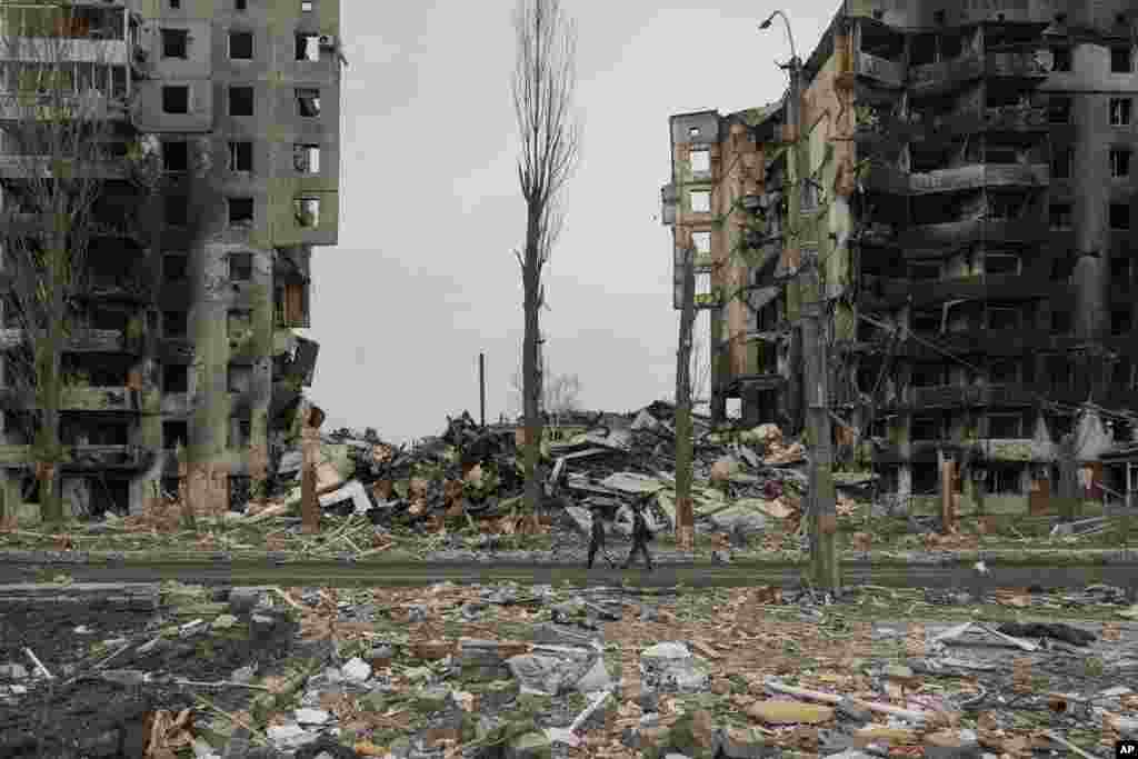 People walk by an apartment building destroyed during fighting between Ukrainian and Russian forces in Borodyanka, Ukraine.