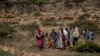 FILE - People walk from a rural area towards a nearby town where a food distribution operated by the Relief Society of Tigray was taking place, near the town of Agula, in the Tigray region of northern Ethiopia, May 8, 2021.