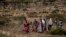 FILE - People walk from a rural area towards a nearby town where a food distribution operated by the Relief Society of Tigray was taking place, near the town of Agula, in the Tigray region of northern Ethiopia, May 8, 2021
