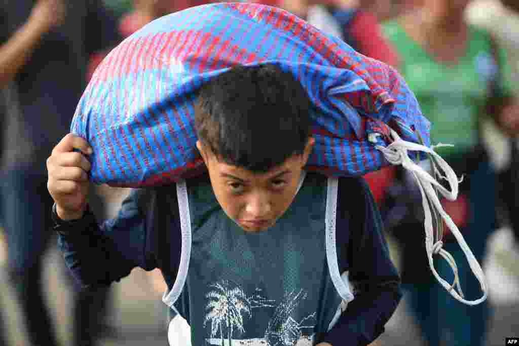 A Honduran migrant boy carries a bag as he takes part in a caravan heading to the U.S. on the road linking Ciudad Hidalgo and Tapachula, Chiapas state, Mexico, Oct. 21, 2018.