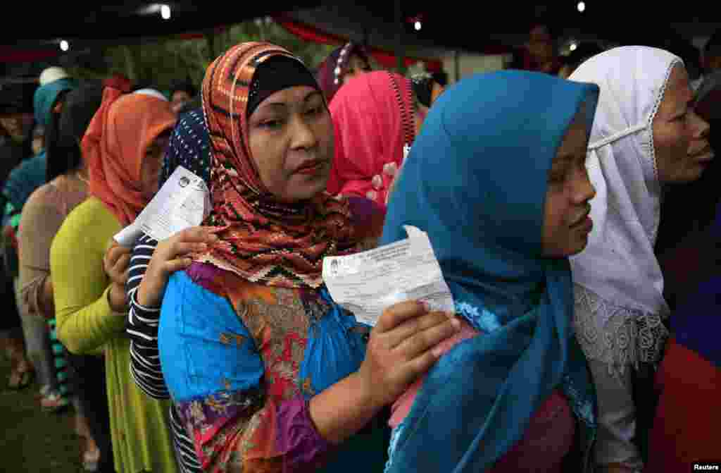 Villagers line up to vote in the country's presidential election at Bojong Koneng polling station in Bogor, Indonesia, July 9, 2014.