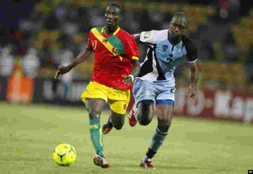 Guinea's Ismael Bangoura (L) challenges Botswana's Ndiyapo Letsholathebe for the ball during their African Nations Cup Group D soccer match at Franceville Stadium January 28, 2012.