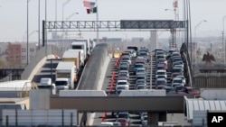 FILE - In this March 29, 2019, photo, cars and trucks line up to enter the U.S. from Mexico at a border crossing in El Paso, Texas. A 2½-year-old Guatemalan child has died after crossing the border, becoming the fourth minor known to have died after being