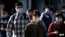 ဘေဂျင်းမြို့တွင် ကိုရိုနာဗိုင်းရပ်စ်ရောဂါကာကွယ်ရန် နှာခေါင်းစည်းတပ်ထားသောပြည်သူများ