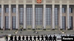 资料照：安保人员走过北京人大会堂前。
