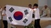 Jóvenes peregrinos de Corea del Sur celebran con su bandera nacional y con el Papa Francisco después de que anunció que la próxima Jornada Mundial de la Juventud será en Seúl, Corea del Sur, en 2027, luego de una misa en el Parque Tejo en Lisboa, el domingo 6 de agosto de 2023 .