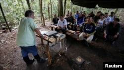 Marco Leon Calarca, (L) a member of the Revolutionary Armed Forces of Colombia (FARC), talks to members of FARC, at a camp to prepare for an upcoming congress ratifying a peace deal with the government, near El Diamante in Yari Plains, Colombia, September