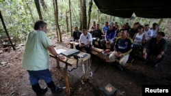 Marco Leon Calarca, (L) a member of the Revolutionary Armed Forces of Colombia (FARC), talks to members of FARC, at a camp near El Diamante in Yari Plains, Colombia, Sept. 9, 2016.