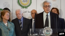 Syria peace envoy Lakhdar Brahimi, behind podium at Arab League headquaraters in Cairo Oct. 24, 2012. Seen in the background from left are former president of Ireland Mary Robinson (R) and former US president Jimmy Carter (2nd L)