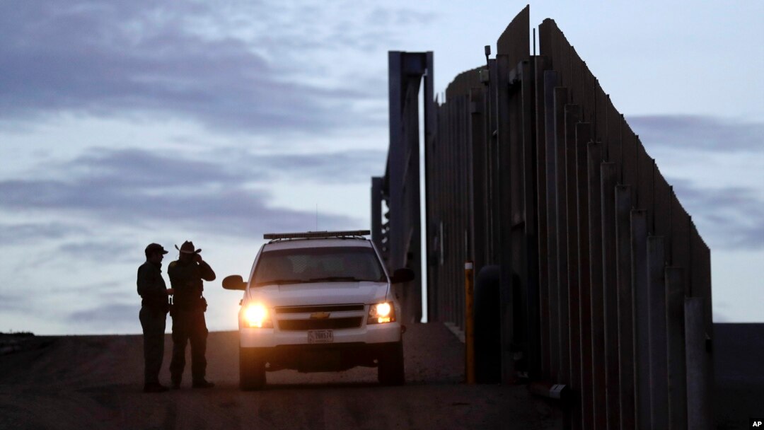 FILE - United States Border Patrol agents stand by a vehicle near one of the border walls separating Tijuana, Mexico and San Diego, in San Diego, Nov. 21, 2018.