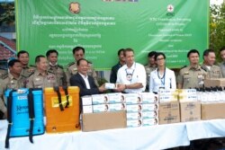 A representaive from the International Committee of the Red Cross (ICRC) is pictured with Prisons Department Director Chan Kimseng at a handover ceremony to provide protective gears to combat the spread of Covid-19 at Prey Sar prison in Dangkor district, Phnom Penh, Cambodia, April 9, 2020. (Malis Tum/VOA)