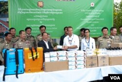 A representaive from the International Committee of the Red Cross (ICRC) is pictured with Prisons Department Director Chan Kimseng at a handover ceremony to provide protective gears to combat the spread of Covid-19 at Prey Sar prison in Dangkor district, Phnom Penh, Cambodia, April 9, 2020. (Malis Tum/VOA)