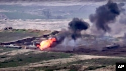 In this image taken from a footage released by Armenian Defense Ministry on Sept. 27, 2020, Armenian forces destroy an Azerbaijani military vehicle at the contact line of the self-proclaimed Republic of Nagorno-Karabakh, Azerbaijan. 