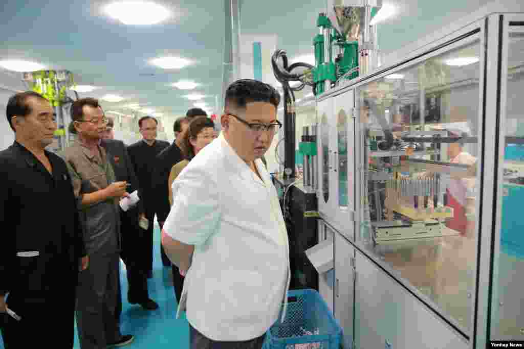 김정은 국무위원장이 새 치과용품 공장의 생산시설을 살피고 있다.