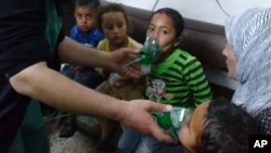 In this image taken from video obtained from the Shaam News Network, posted on April 16, 2014, an anti-Bashar Assad activist group, which has been authenticated based on its contents and other AP reporting, children are seen receiving oxygen in Kfar Zeita