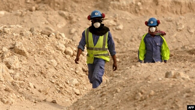 Para pekerja berjalan kembali ke tempat kerja Stadion Al-Wakra yang sedang dibangun untuk Piala Dunia 2022, di Doha, Qatar, 4 Mei 2015.