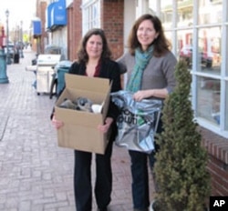 New Jersey shoe store owner Louise Van Osten and customer Jill Shobe with a carton of donated used shoes that are bound for Haiti.